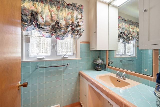 bathroom featuring tile walls, vanity, and a healthy amount of sunlight