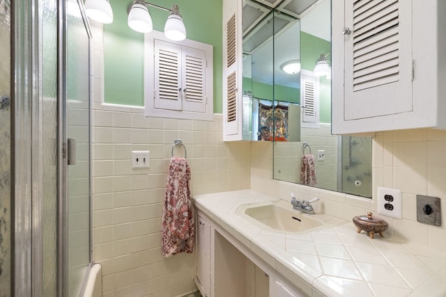 bathroom featuring a shower with door, vanity, tile walls, and tasteful backsplash