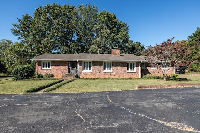 single story home featuring a front lawn