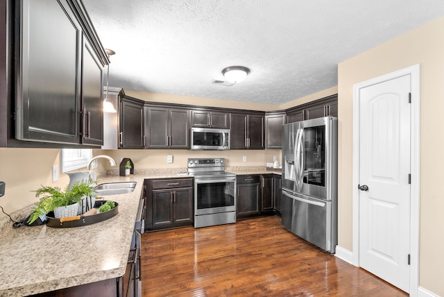 kitchen featuring dark brown cabinets, appliances with stainless steel finishes, sink, and dark hardwood / wood-style floors