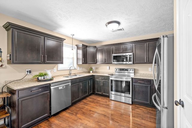 kitchen with dark brown cabinets, appliances with stainless steel finishes, sink, and dark hardwood / wood-style flooring