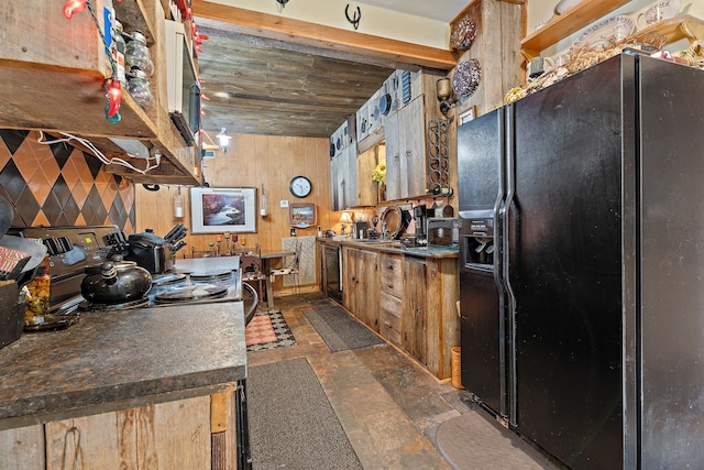 kitchen featuring wood walls, range, sink, and black fridge with ice dispenser