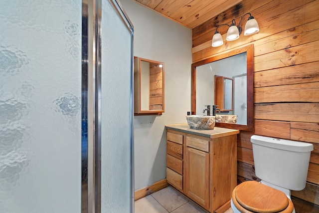 bathroom featuring tile patterned floors, toilet, wooden walls, wooden ceiling, and vanity