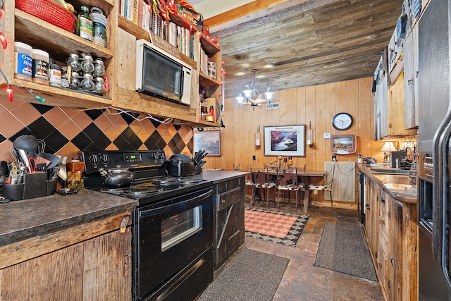 kitchen featuring backsplash, sink, electric range, an inviting chandelier, and wood walls