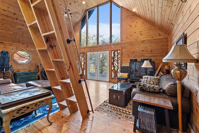 living room featuring french doors, light hardwood / wood-style flooring, high vaulted ceiling, and a healthy amount of sunlight