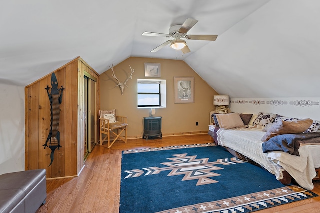 bedroom featuring ceiling fan, hardwood / wood-style flooring, and vaulted ceiling