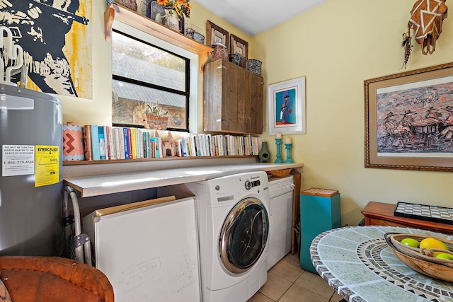 clothes washing area featuring washer and dryer, light tile patterned flooring, and water heater