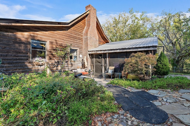 back of property with a patio and a sunroom