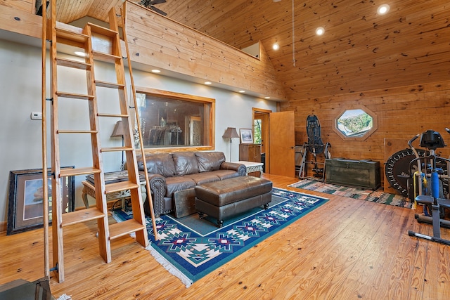 living room featuring wooden walls, hardwood / wood-style floors, high vaulted ceiling, and wooden ceiling