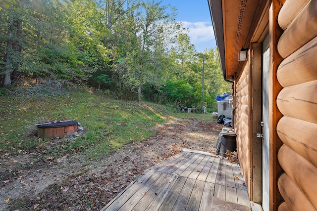 view of yard featuring a deck and an outdoor fire pit