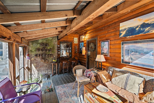 living room featuring lofted ceiling with beams, wood-type flooring, and rustic walls