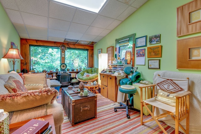 living room with a drop ceiling and vaulted ceiling