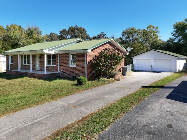 view of front of home featuring a front yard, an outbuilding, a garage, and covered porch