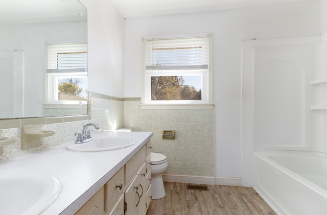 full bathroom featuring tile walls, vanity, hardwood / wood-style floors, and toilet