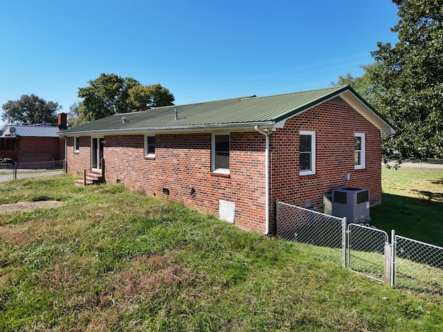 view of property exterior with central AC and a lawn