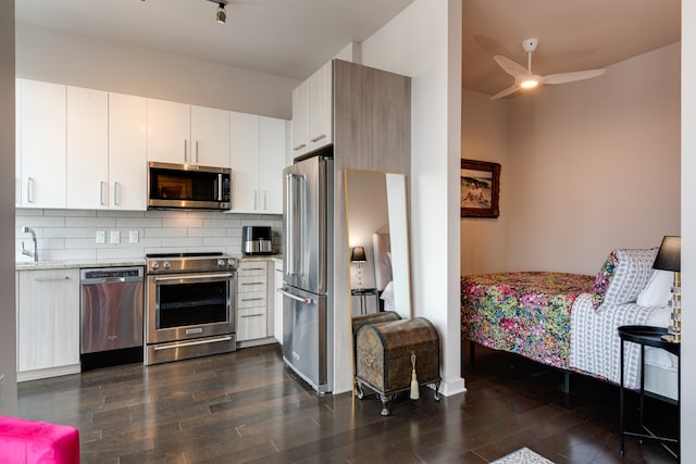 kitchen featuring decorative backsplash, ceiling fan, dark hardwood / wood-style flooring, white cabinetry, and stainless steel appliances