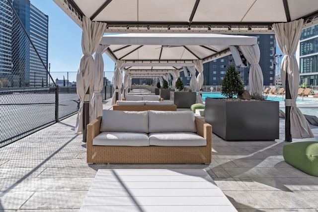 view of patio / terrace with a gazebo, an outdoor living space, and a swimming pool