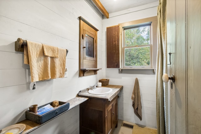 bathroom with vanity and wood walls