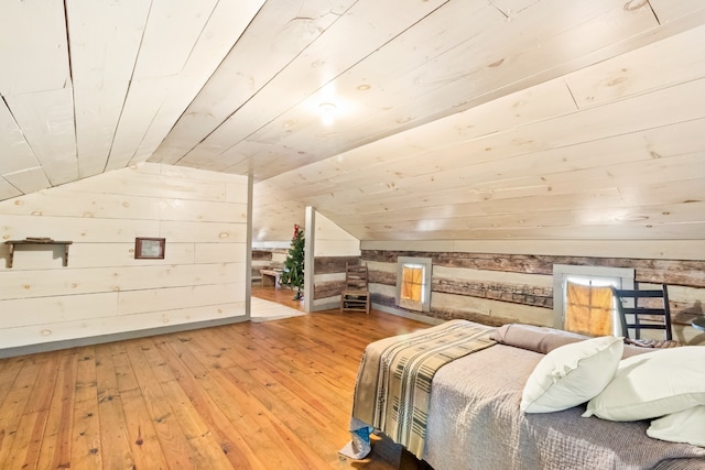 bedroom featuring wood ceiling, lofted ceiling, wooden walls, and hardwood / wood-style floors