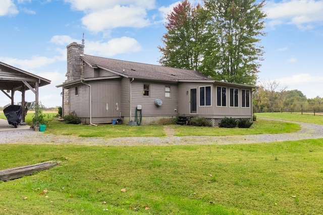 rear view of property featuring a lawn