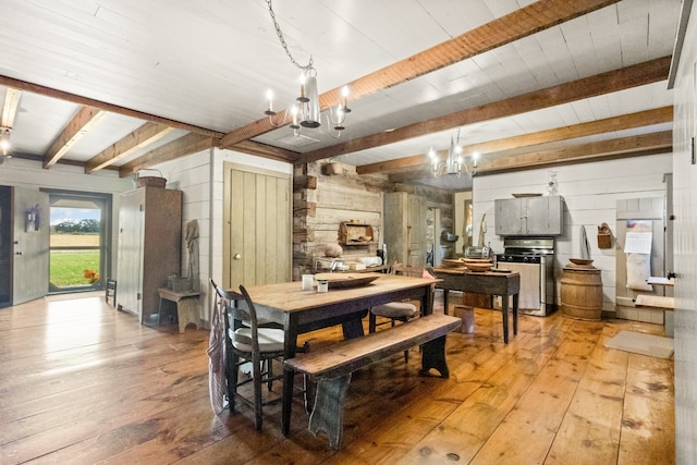 dining area with light hardwood / wood-style floors, a notable chandelier, and beam ceiling