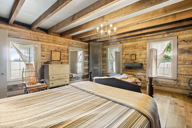 unfurnished bedroom with a notable chandelier, beam ceiling, hardwood / wood-style flooring, and wooden walls