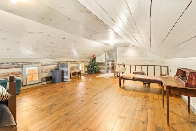 additional living space featuring light hardwood / wood-style flooring, lofted ceiling, wood walls, and wood ceiling