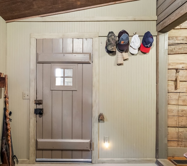 entryway with wood walls and lofted ceiling