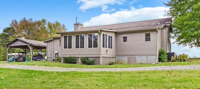 rear view of house featuring a yard and a carport