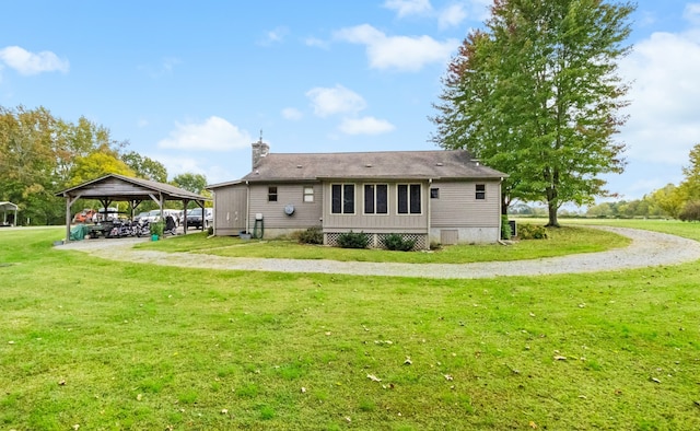 rear view of property with a gazebo and a yard