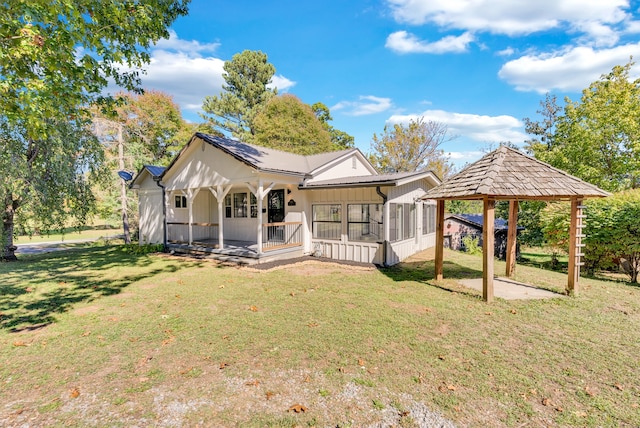 back of property featuring a gazebo and a lawn