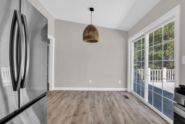 606 S Chestnut St, Monterey, TN 38574 - unfurnished dining area with visible vents, light wood finished floors, lofted ceiling, and baseboards