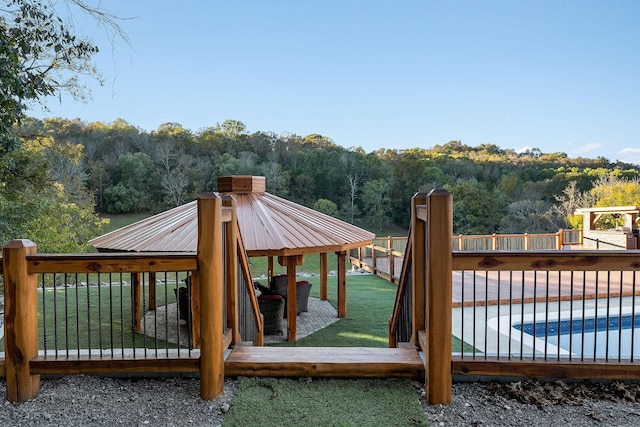43 Landfill Ln, Brush Creek, TN 38547 - wooden deck featuring fence, a lawn, a fenced in pool, and a wooded view