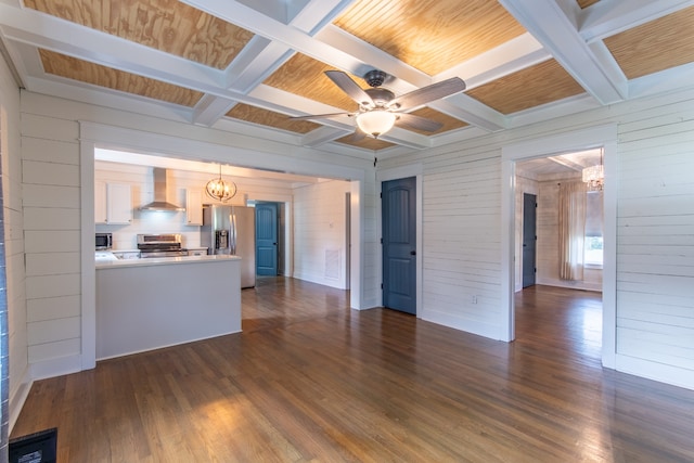 unfurnished living room with beamed ceiling, dark wood-type flooring, coffered ceiling, and wood walls