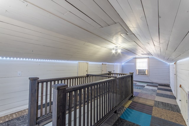 hallway with wood walls, vaulted ceiling, cooling unit, and wooden ceiling