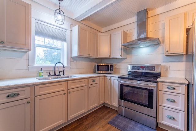 kitchen featuring wall chimney range hood, sink, appliances with stainless steel finishes, dark hardwood / wood-style flooring, and pendant lighting