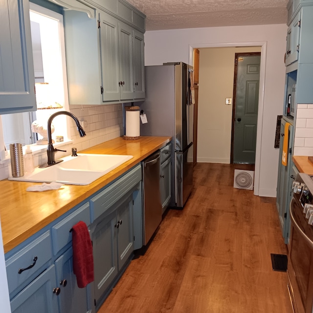 kitchen featuring butcher block counters, appliances with stainless steel finishes, and light hardwood / wood-style floors