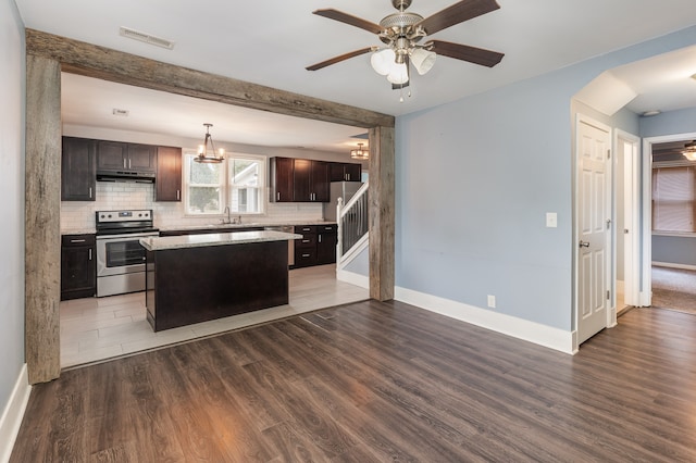 kitchen with hardwood / wood-style flooring, a center island, stainless steel electric range oven, and backsplash