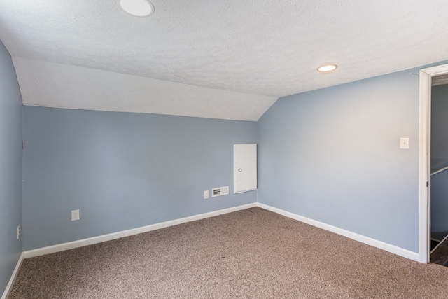 bonus room featuring a textured ceiling, vaulted ceiling, and carpet flooring