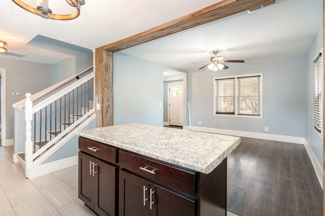 kitchen featuring light hardwood / wood-style flooring, dark brown cabinets, a center island, and ceiling fan