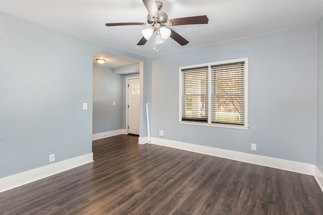 spare room with dark wood-type flooring and ceiling fan