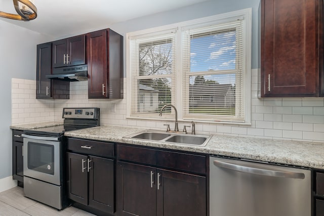 kitchen featuring light stone countertops, appliances with stainless steel finishes, sink, and decorative backsplash