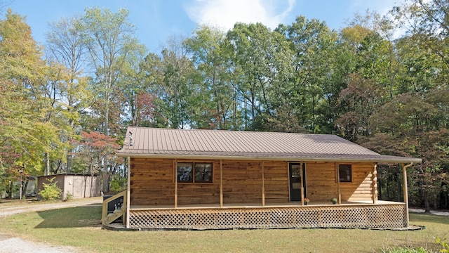 view of front facade with a storage shed, a front yard, and a deck