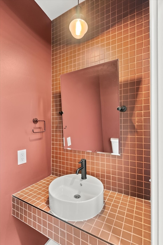 bathroom with toilet, tile walls, sink, and backsplash