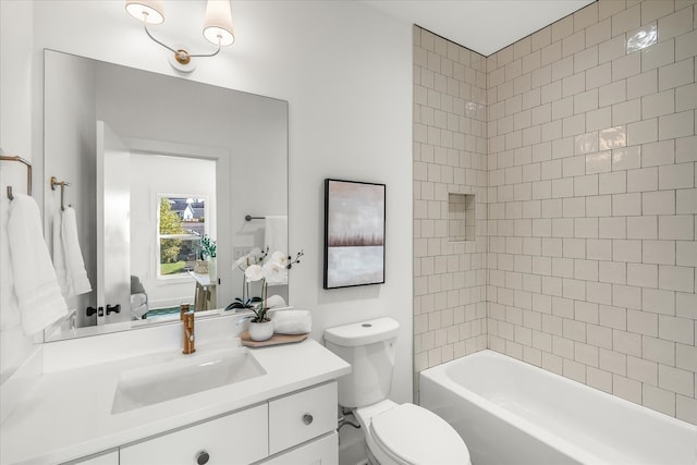 full bathroom featuring vanity, tiled shower / bath combo, and toilet