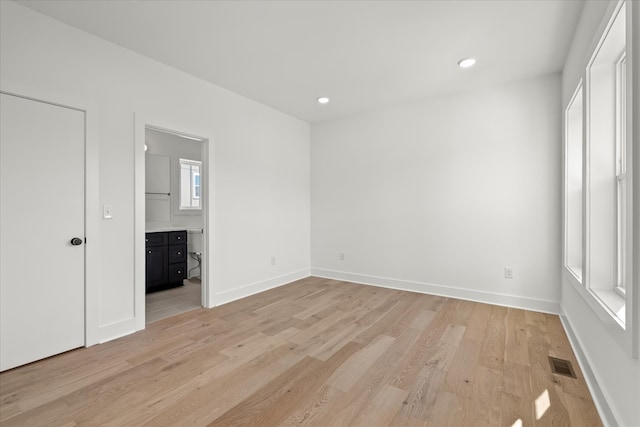 unfurnished bedroom featuring connected bathroom and light hardwood / wood-style floors