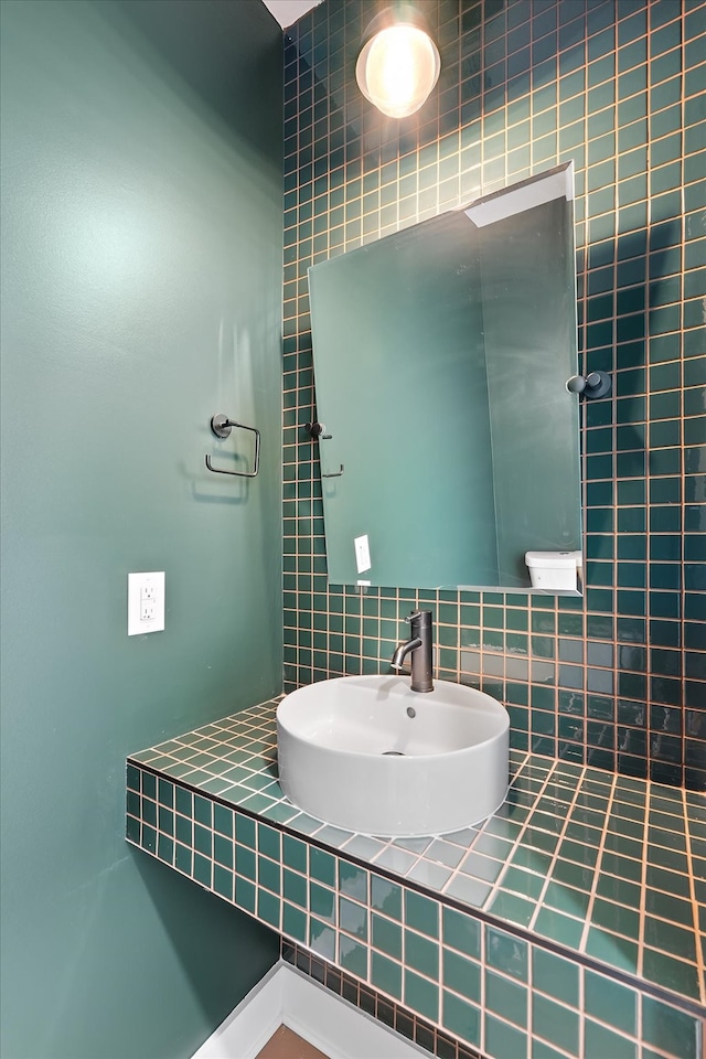 bathroom featuring tile walls and sink