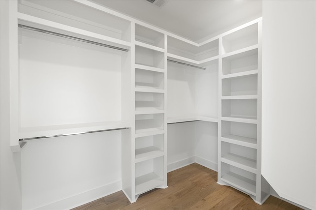 walk in closet with hardwood / wood-style floors