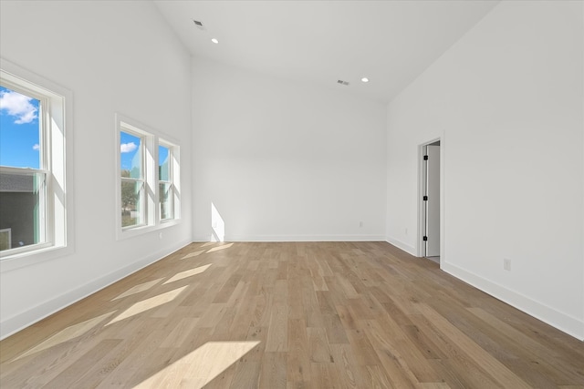 unfurnished room with light hardwood / wood-style flooring and high vaulted ceiling