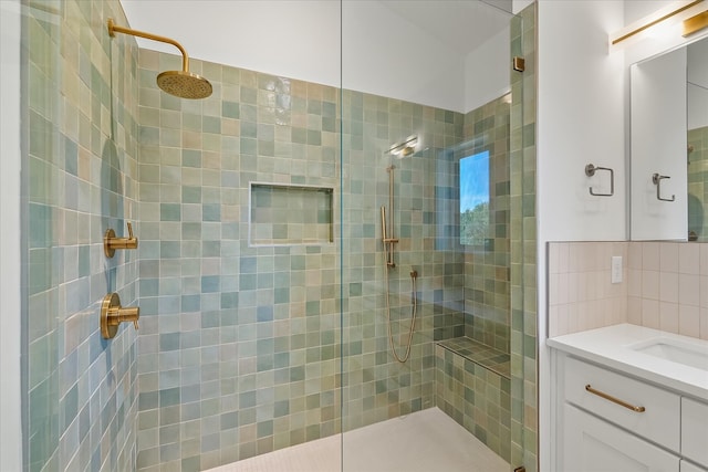 bathroom featuring vanity, decorative backsplash, and a shower with shower door